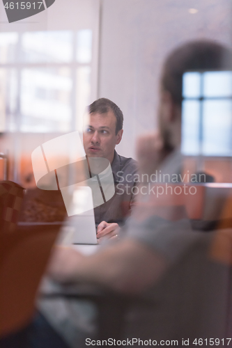 Image of businessman working using a laptop in startup office