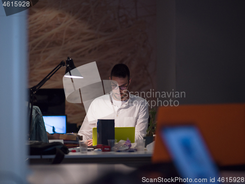 Image of businessman working using a laptop in startup office