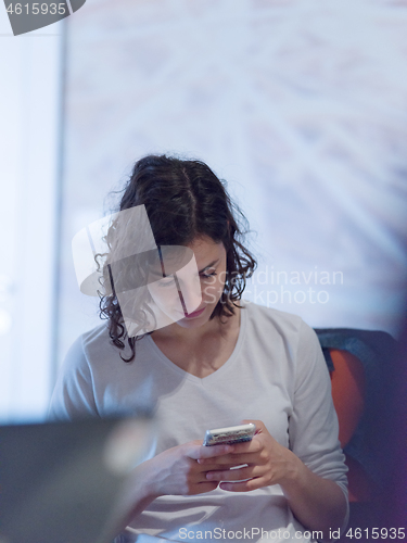 Image of Businesswoman typing on phone  in office