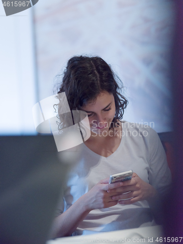 Image of Businesswoman typing on phone  in office