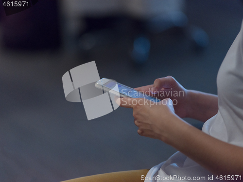 Image of Businesswoman typing on phone  in office