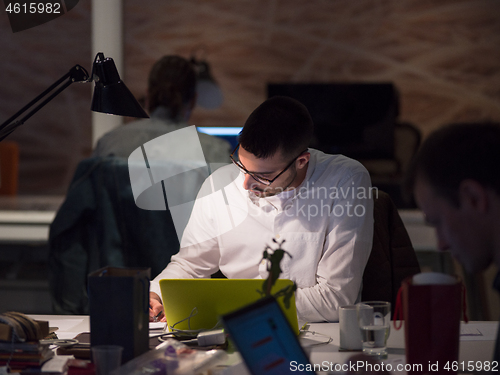 Image of businessman working using a laptop in startup office