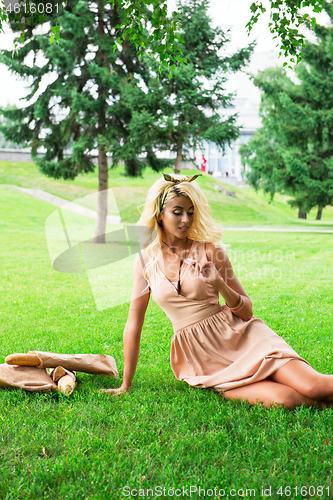 Image of eauty blonde alone young woman resting in the park