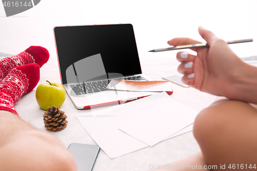 Image of caucasian couple at home using internet technology LLaptop and phone for people sitting on the floor