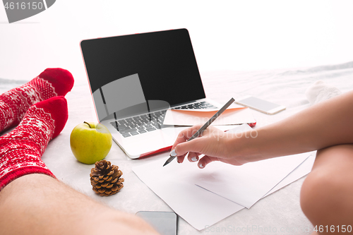 Image of caucasian couple at home using internet technology LLaptop and phone for people sitting on the floor