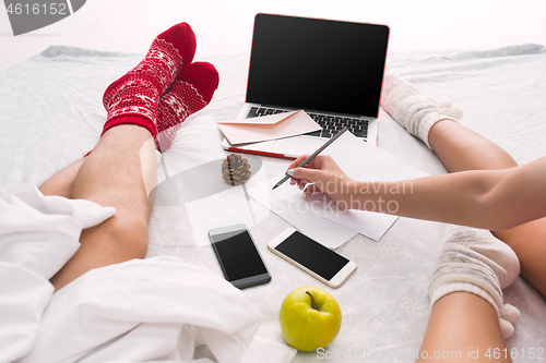 Image of caucasian couple at home using internet technology LLaptop and phone for people sitting on the floor