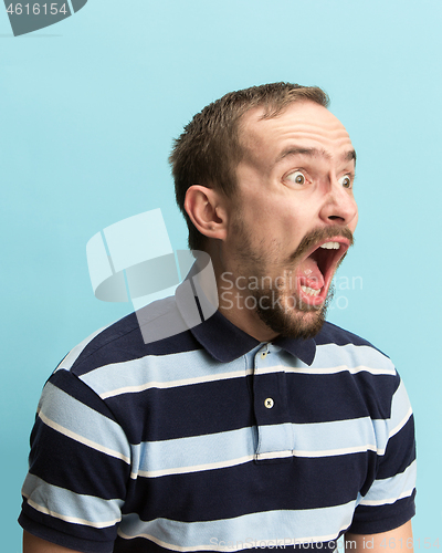 Image of The man screaming with open mouth isolated on blue background, concept face emotion