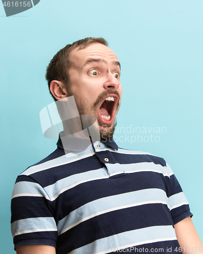 Image of The man screaming with open mouth isolated on blue background, concept face emotion