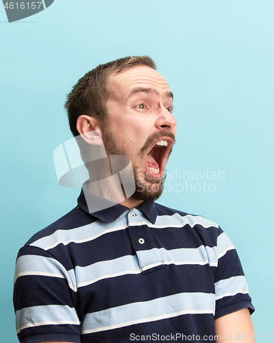 Image of The man screaming with open mouth isolated on blue background, concept face emotion