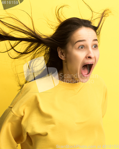 Image of The woman screaming with open mouth isolated on yellow background, concept face emotion