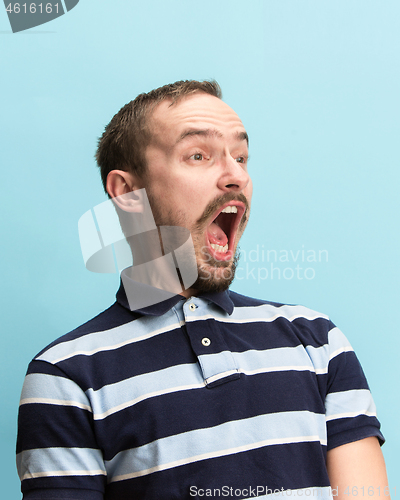 Image of The man screaming with open mouth isolated on blue background, concept face emotion