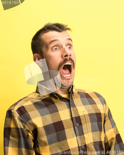 Image of The man screaming with open mouth isolated on yellow background, concept face emotion