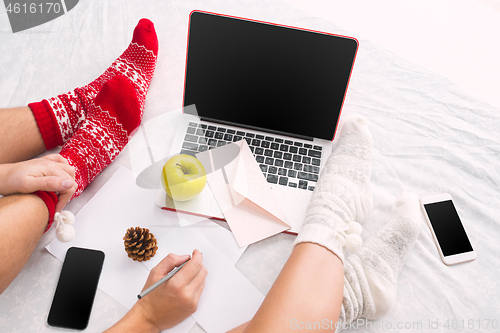 Image of caucasian couple at home using internet technology LLaptop and phone for people sitting on the floor