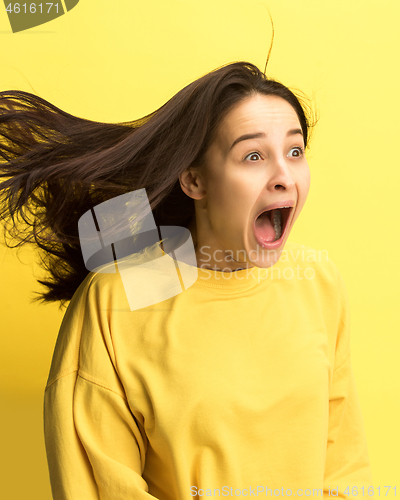 Image of The woman screaming with open mouth isolated on yellow background, concept face emotion