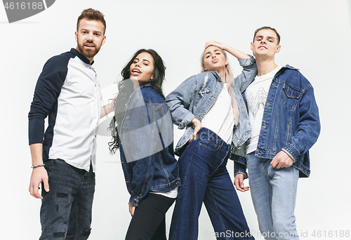 Image of Group of smiling friends in fashionable jeans