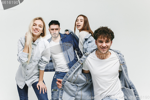 Image of Group of smiling friends in fashionable jeans