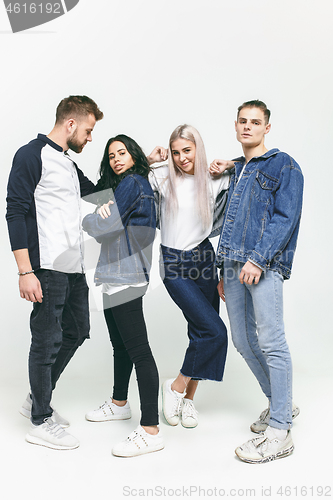 Image of Group of smiling friends in fashionable jeans