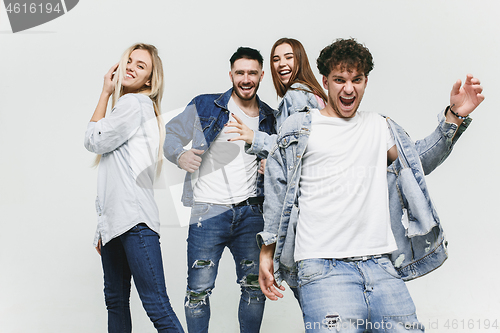 Image of Group of smiling friends in fashionable jeans