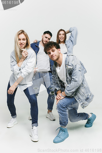 Image of Group of smiling friends in fashionable jeans