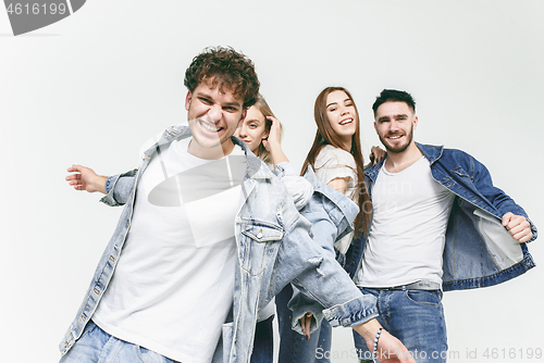 Image of Group of smiling friends in fashionable jeans