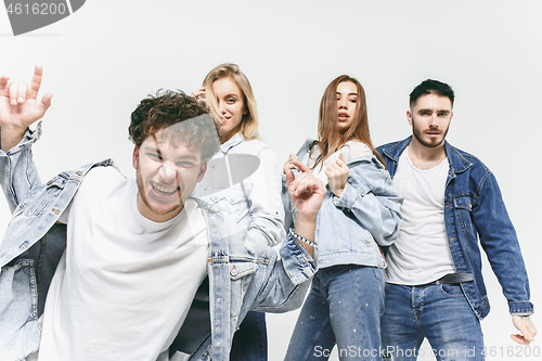 Image of Group of smiling friends in fashionable jeans