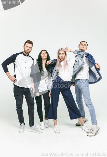 Image of Group of smiling friends in fashionable jeans