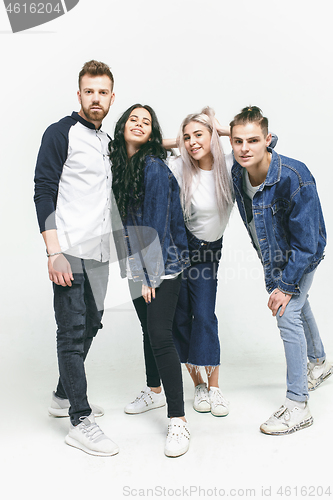 Image of Group of smiling friends in fashionable jeans