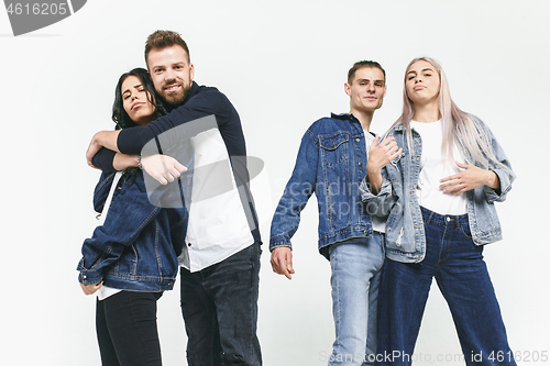 Image of Group of smiling friends in fashionable jeans