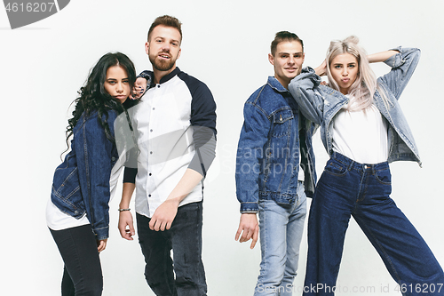 Image of Group of smiling friends in fashionable jeans