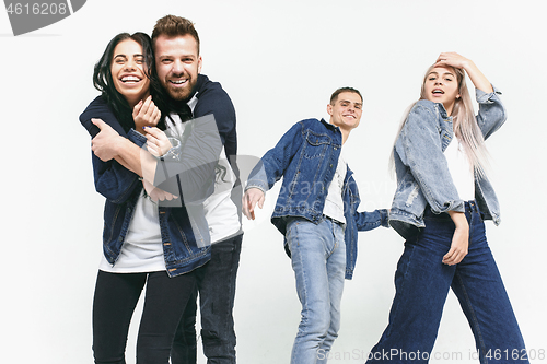 Image of Group of smiling friends in fashionable jeans