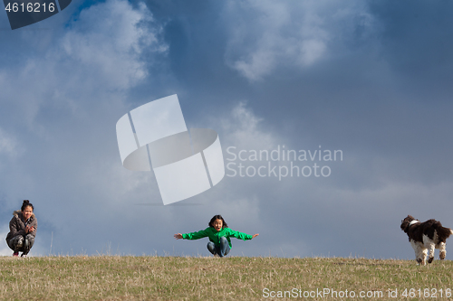 Image of Cutes girls with  a dog on a field in the summer