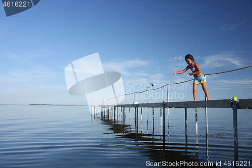 Image of Cute girl fishing crabs at the beach in the summer