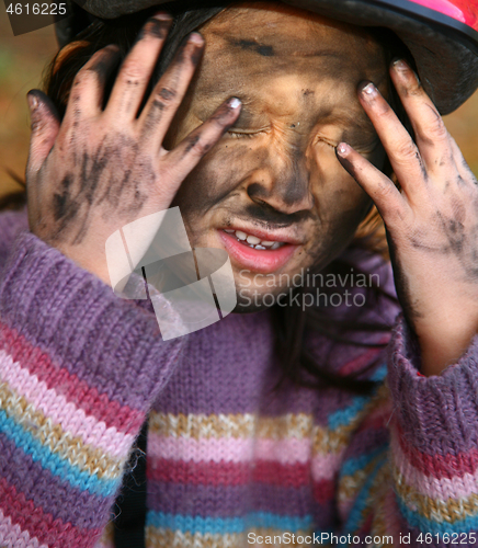 Image of Portrait of a young cute girl looking at the camera putting coal