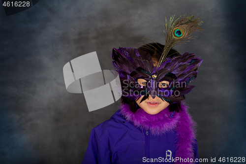 Image of Portrait of a young cute girl with a mask  looking at the camera