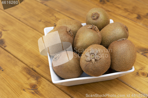 Image of Eight hairy kiwi fruit in a white china bowl