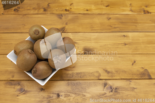 Image of Fresh kiwi fruits piled in a bowl on a table