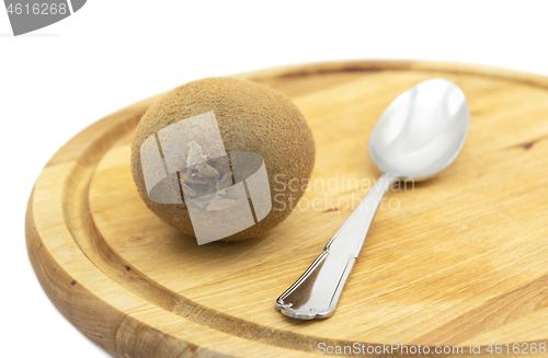 Image of Fresh kiwi fruit with a spoon on a wooden board
