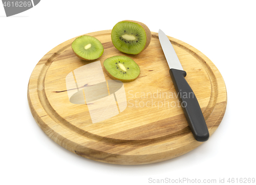 Image of Fresh kiwi sliced with knife, with slices on wooden board 