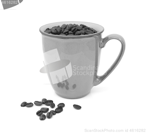 Image of Coffee beans in a mug and spilled beside