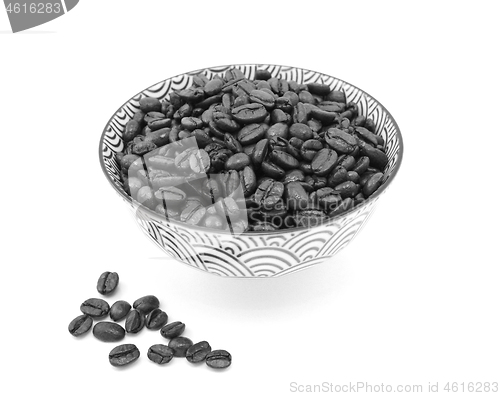 Image of Roasted coffee beans in a bowl, some spilled beside