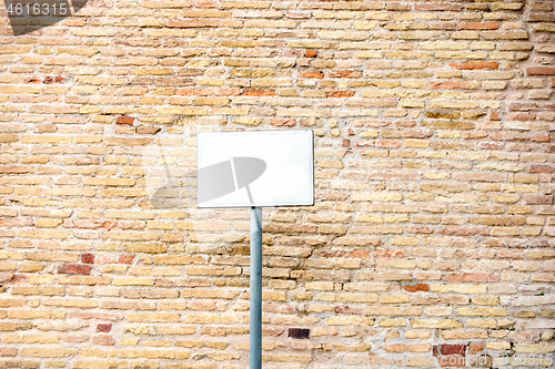 Image of typical red brick wall background with blank white plaque