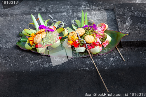 Image of Votive offering with flowers, cookies and ribbons