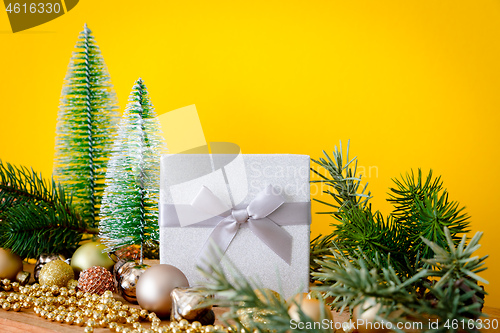 Image of Christmas decoration glass balls with fir trees on yellow backgr