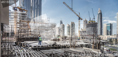 Image of Laborers working on modern constraction site works in Dubai. Fast urban development consept