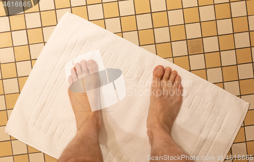 Image of After taking a shower; Male feet on a vintage bathroom floor