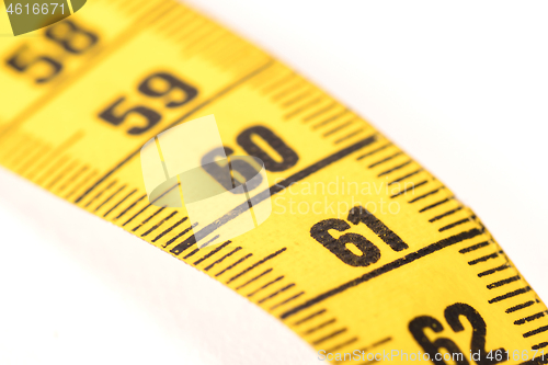 Image of Close-up of a yellow measuring tape isolated on white - 61