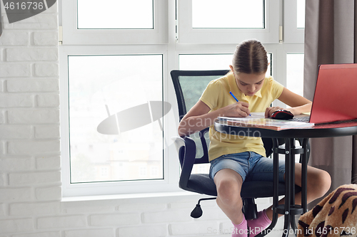 Image of Quarantined girl doing homework via distance learning