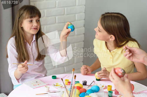 Image of Girl shows sister how she painted an Easter egg