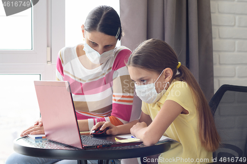 Image of Quarantined mom and her child do homework online