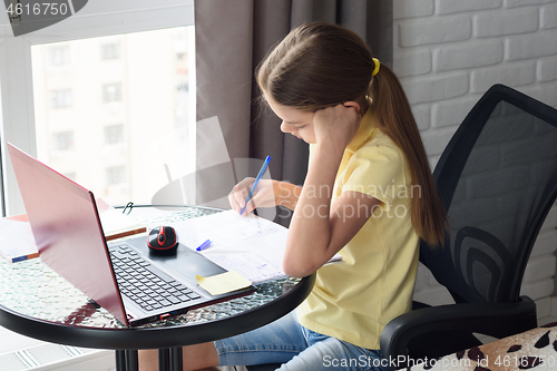 Image of Girl at home doing online lessons while sitting at the computer